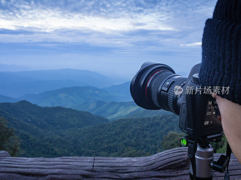 摄影师在山顶拍摄风景