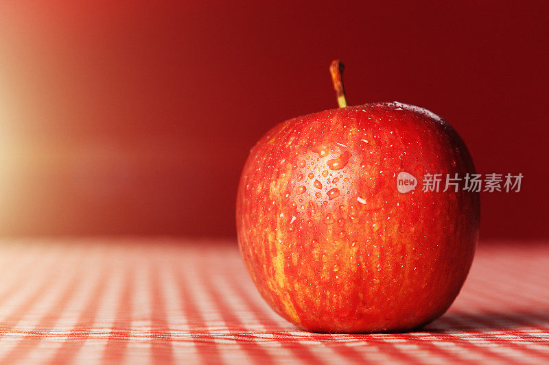 红格子布上放着成熟的红苹果