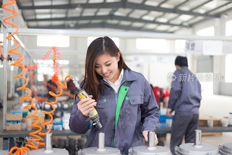 年轻的亚洲妇女在车间工作
