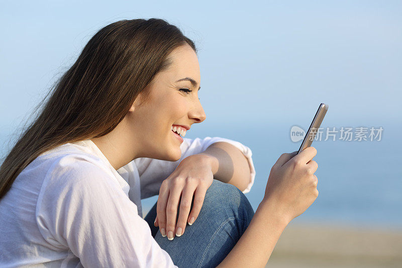 女孩微笑着在智能手机上阅读在线内容