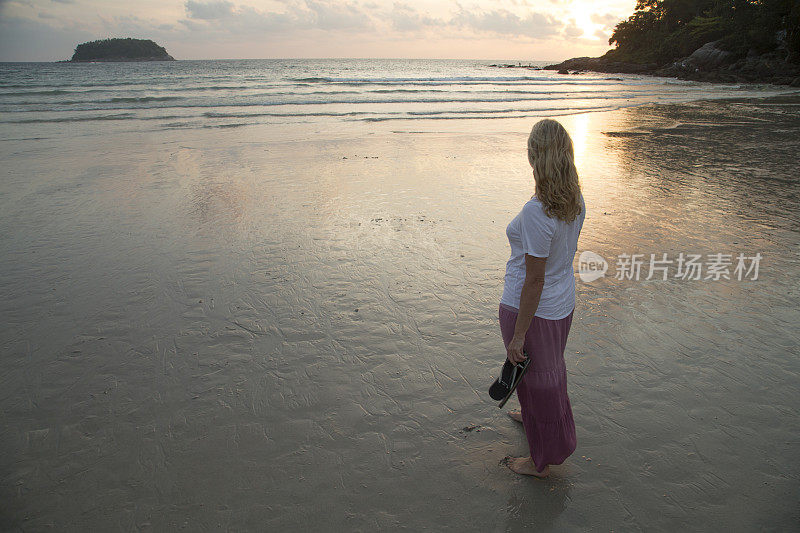 一个女人从海滩眺望大海