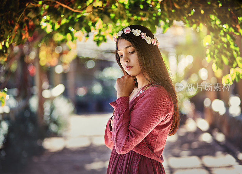 美丽的黑发姑娘站在枝繁叶茂的凉亭向下看