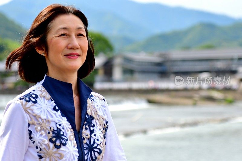 一名日本妇女在京都岚山河畔散步