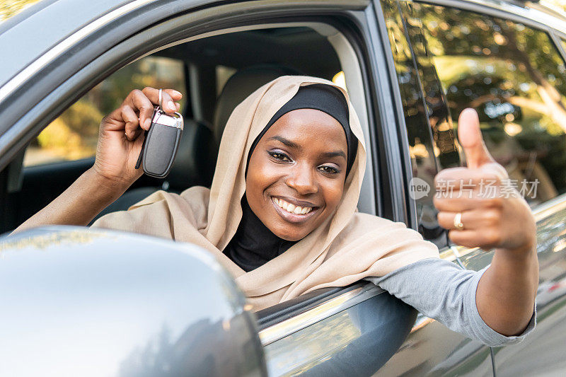 微笑的黑人穆斯林妇女展示她的车钥匙
