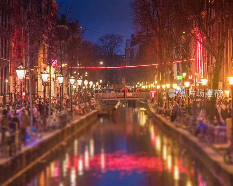 红灯区从街上看阿姆斯特丹的一排排商店，有轨电车游客和自行车在阿姆斯特丹。阿姆斯特丹是荷兰的首都。