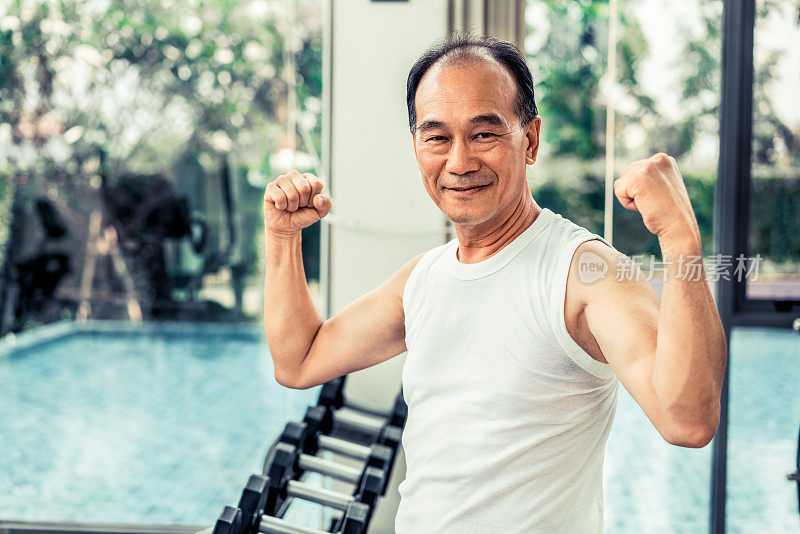 快乐健康的老爷爷在健身房健身。
