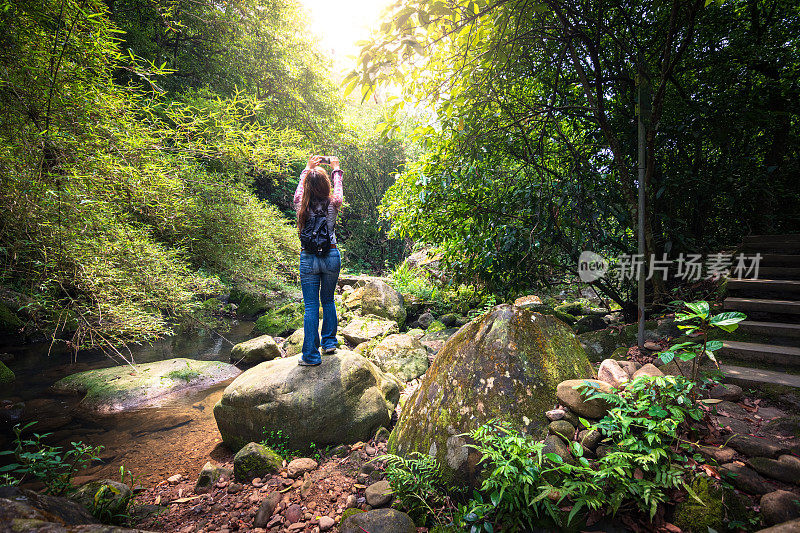 台湾台牌元觉瀑布徒步旅行路线上的一名女子拍摄小溪奔跑的照片