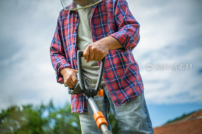 那位老人正在院子里割草