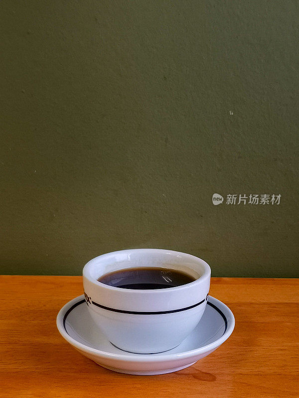 木桌上放着一杯美式咖啡