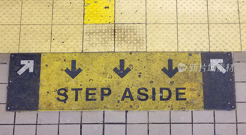 纽约地铁站台地板上的“让开”标记