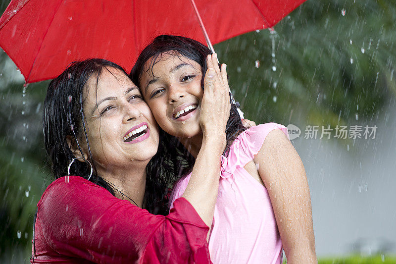 快乐的母亲和女儿在雨中