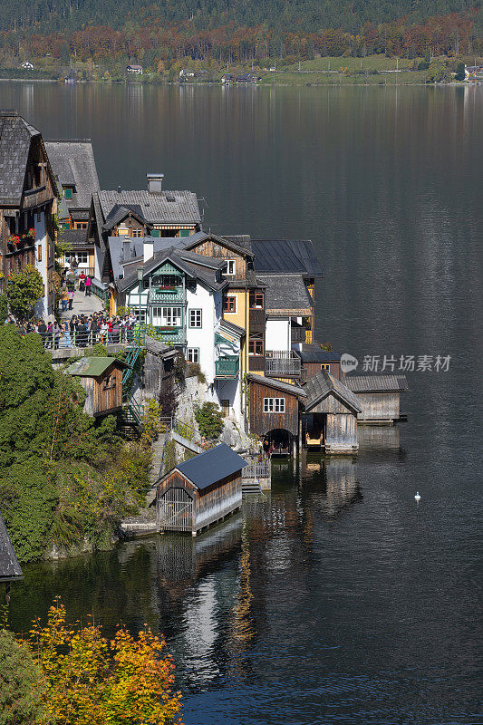 哈尔斯塔特与游客在最著名的照片景点与房屋建造在山上，秋天的颜色，奥地利