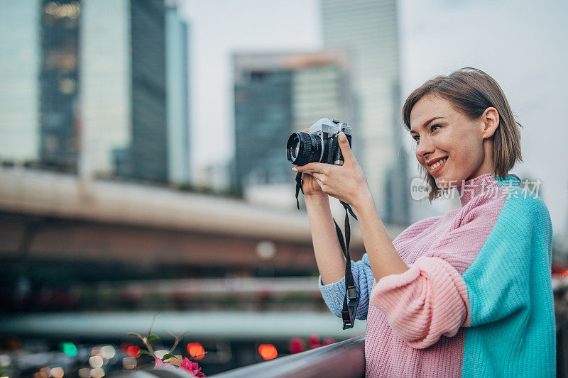 在城市里用相机拍照的女人