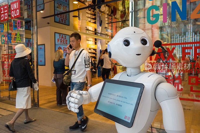 在东京银座的优衣库旗舰店，一个机器人在迎接顾客。