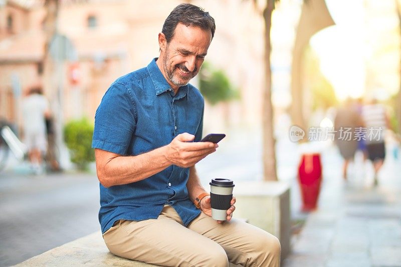 中年英俊的商人用智能手机喝酒带走咖啡微笑