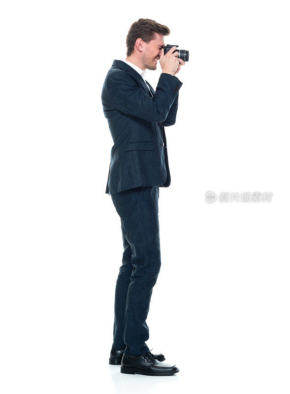 白人年轻男性摄影师站着，穿着衬衫，拿着相机