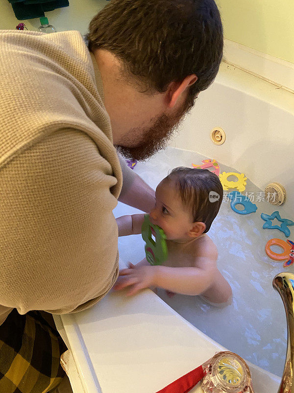 父亲正在给11个月大的儿子洗澡