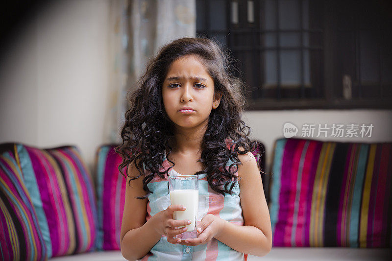印度女孩拿着一杯牛奶的照片