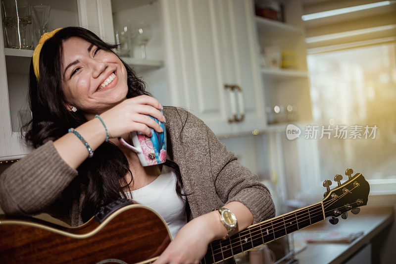 厨房里拿着吉他的女人