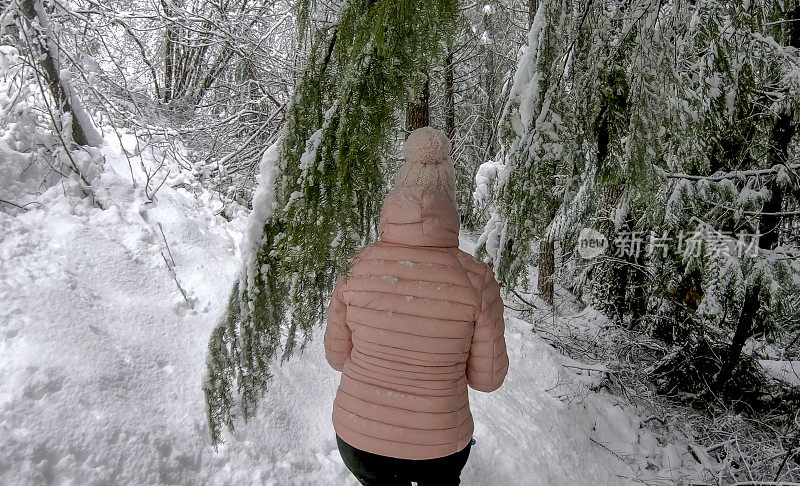 女性徒步旅行者沿着雪道行走