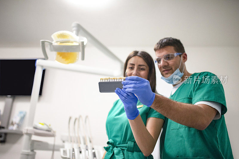 一个年轻的牙医小组在看一颗牙齿的快照