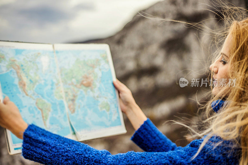 女旅行者在荒野地区查看地图寻找方向