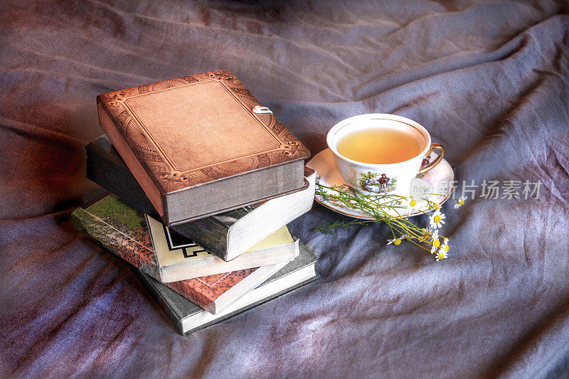 床上放着书和一杯茶