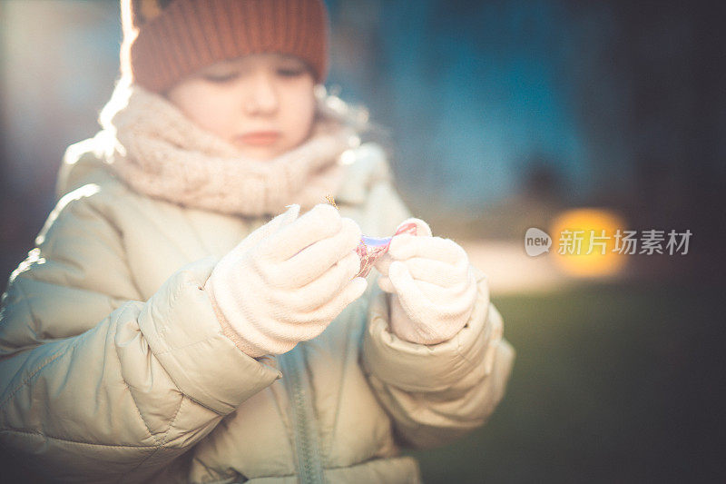 一个学龄前的小女孩手里拿着盒子里的圣诞装饰品