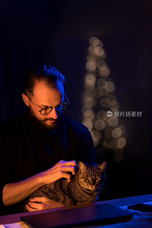 男人和他的猫在家里的节日夜晚