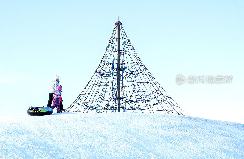 家人在冬天度假。一个女人和一个5岁的白种人孩子在爬山。