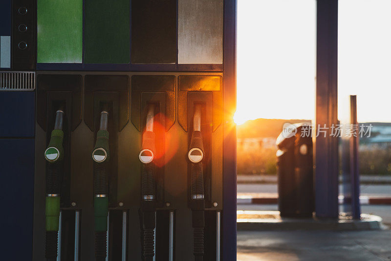 阳光明媚的日子，位于城市街道加油站的油泵和加油机。
