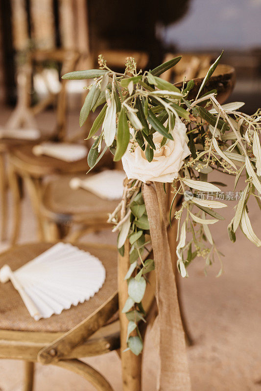 近距离的婚礼椅子与鲜花的安排和白色西班牙手扇