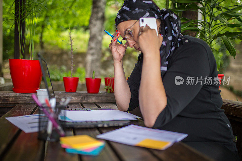 女人在家里使用电话并做笔记