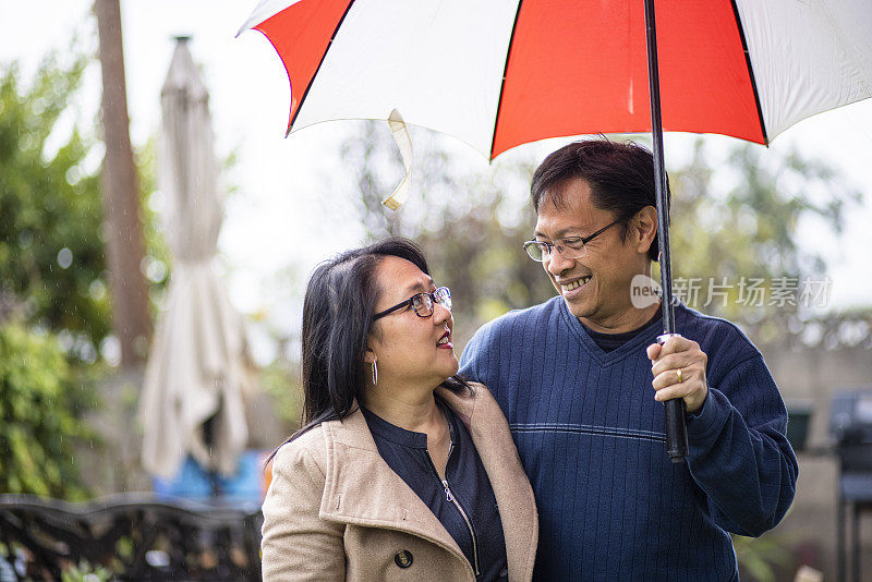 雨中撑伞的亚洲情侣