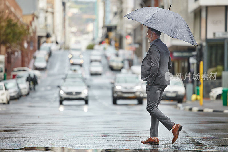 一个英俊的商人在下雨天步行去上班