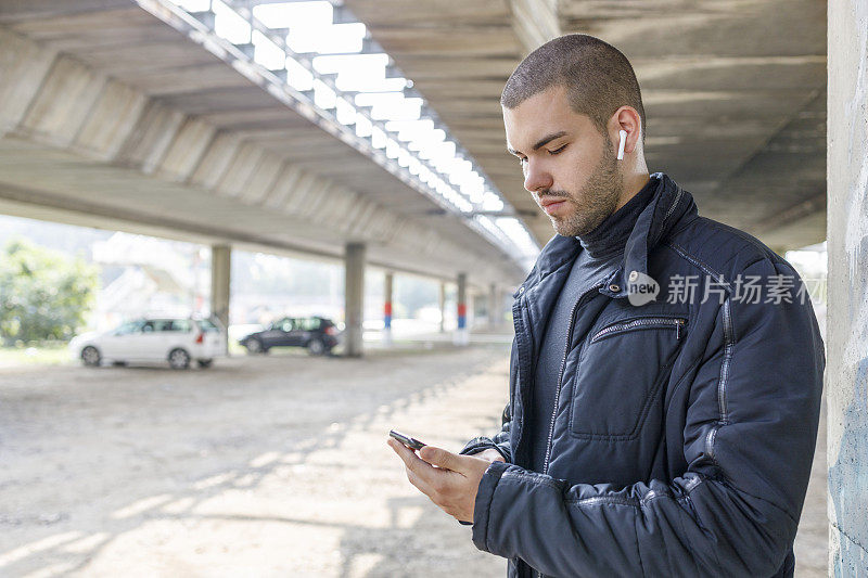 男人通过智能手机和耳机听音乐