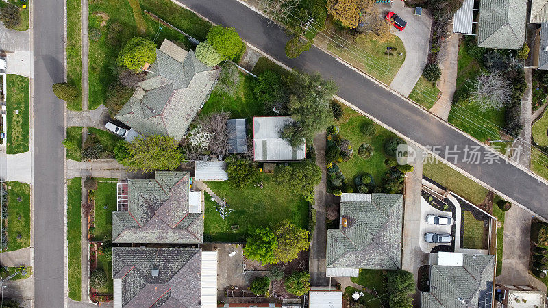 在墨尔本远郊一条安静的街道上，用无人机从上到下俯瞰着一个由20世纪中期的澳大利亚房屋和庭院组成的小社区