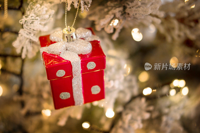 特写圣诞树装饰小红色礼物与银弓。