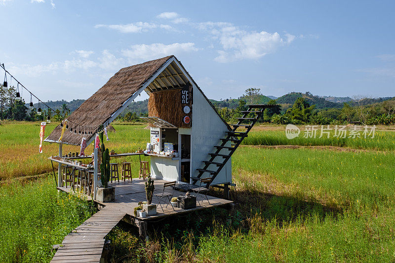 在泰国南部，人们在有白色楼梯的稻田里参观一家咖啡馆