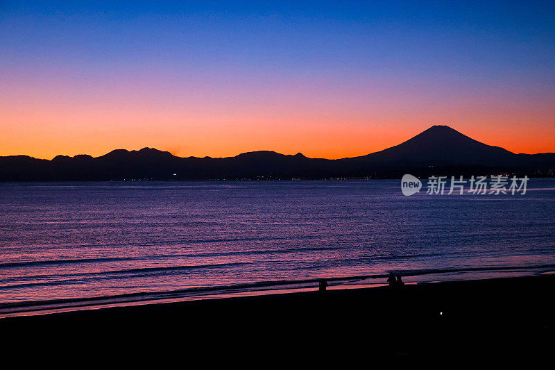 夕阳下，沙滩上的富士山轮廓