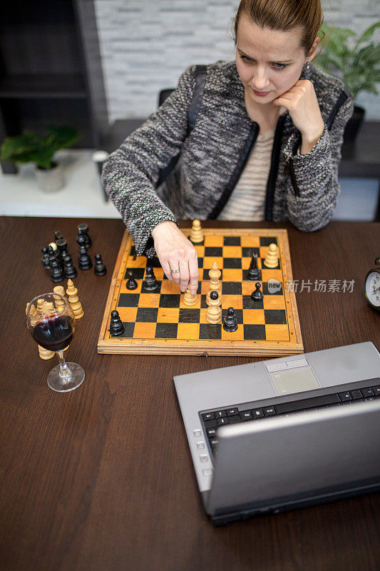 一位女商人在隔离期间在家在线下棋