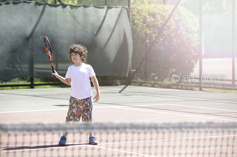 年轻健康快乐的男孩在户外球场网球初学者