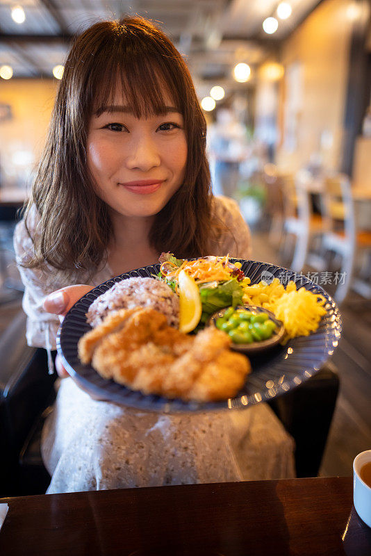 咖啡馆里拿着午餐盘的美女