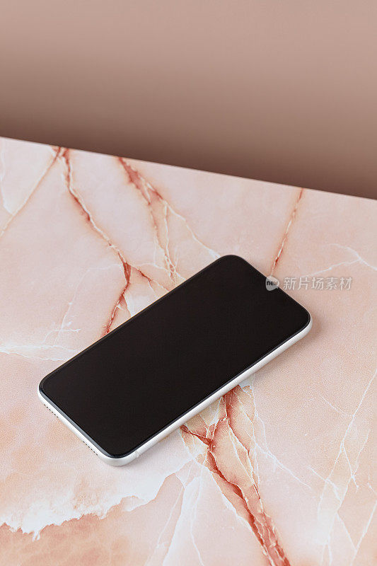 手机模型，手机与空白屏幕，手机，智能手机模型，设备是米色粉红色大理石背景。