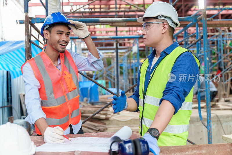 亚洲建筑工程师的团队合作，在施工现场一起工作和讨论。