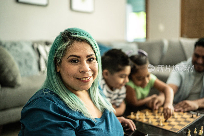 一个母亲和她的家人在家里下棋的画像
