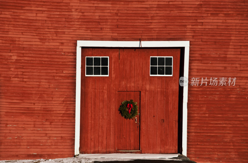 带有圣诞花环的旧红色谷仓门