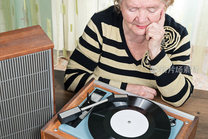 老妇人在听转盘上的音乐