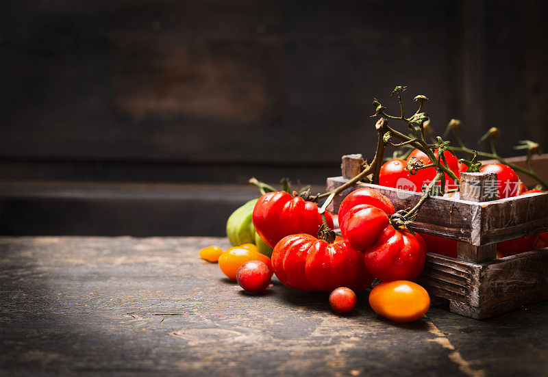 新鲜的有机花园番茄在古董盒上的木制背景。