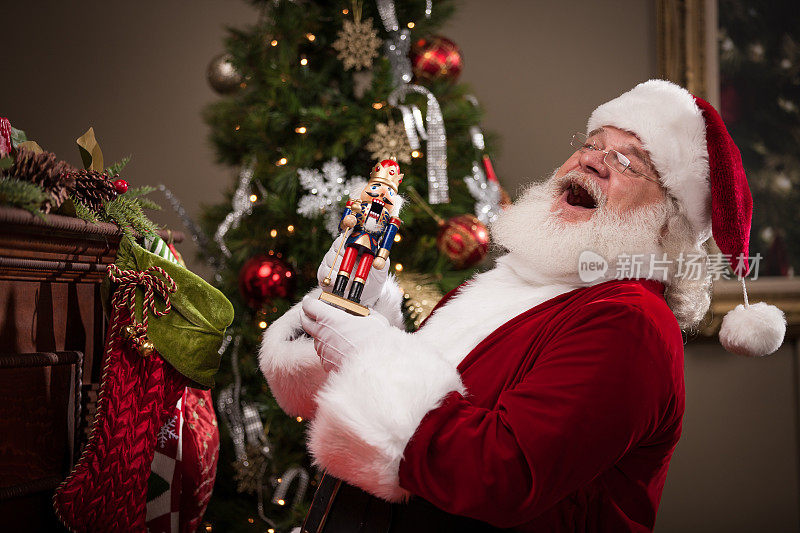 真正的圣诞老人笑着把糖果放进长筒袜
